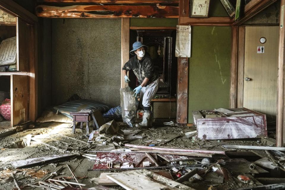 A woman cleans a house devastated by Typhoon Hagibis, in Nagano, central Japan Wednesday, Oct. 16, 2019. The typhoon hit Japan's main island on Saturday with strong winds and historic rainfall that caused more than 200 rivers to overflow, leaving thousands of homes flooded, damaged or without power. (Koki Sengoku/Kyodo News via AP)