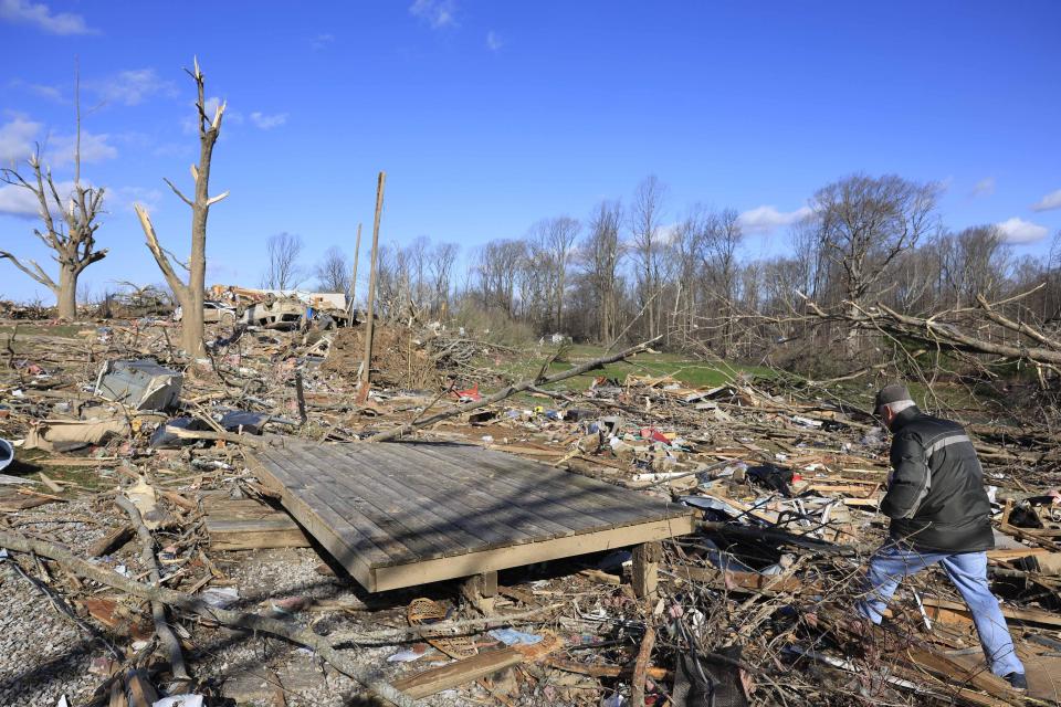 Don Hill collects family photos after a tornado destroyed his son's home on West Cave Mountain Road in Stinesville, Indiana. A tornado struck the area on March 31, 2023, destroyed houses along the road, and hospitalized some residents with injuries. Two people were killed nearby at McCormicks Creek State Park when the tornado destroyed a campground. / Credit: Jeremy Hogan/SOPA Images/LightRocket via Getty Images