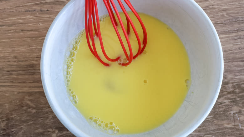 eggs and water whisked together in a bowl