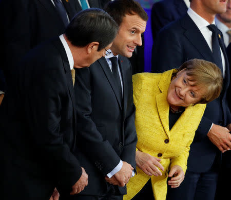 German Chancellor Angela Merkel laughs with French President Emmanuel Macron and President of Cyprus Nicos Anastasiades during a leaders photograph at the European Union leaders summit in Brussels, Belgium December 14, 2017. REUTERS/Phil Noble