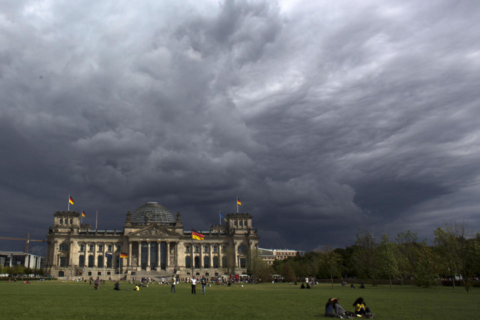 File - In this Tuesday, Aug. 20, 2013 file photo, dark clouds hang over the Reichstag, the German parliament Bundestag building, in Berlin. Hundreds of immigrants are running in Germany's national election on Sunday, raising the possibility of making its next parliament more diverse than ever. While it still might not fully represent the country's overall diversity, where more than a quarter of the population has immigrant roots, it's a step toward a more accurate reflection of society. (AP Photo/Markus Schreiber, File)