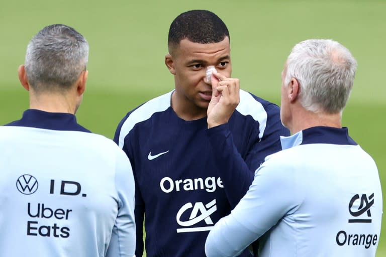 <a class="link " href="https://sports.yahoo.com/soccer/players/3893765/" data-i13n="sec:content-canvas;subsec:anchor_text;elm:context_link" data-ylk="slk:Kylian Mbappe;sec:content-canvas;subsec:anchor_text;elm:context_link;itc:0">Kylian Mbappe</a>, with a plaster on his broken nose, speaks to <a class="link " href="https://sports.yahoo.com/soccer/teams/france/" data-i13n="sec:content-canvas;subsec:anchor_text;elm:context_link" data-ylk="slk:France;sec:content-canvas;subsec:anchor_text;elm:context_link;itc:0">France</a> coach Didier Deschamps at the team's Euro 2024 base in Paderborn on Wednesday (FRANCK FIFE)