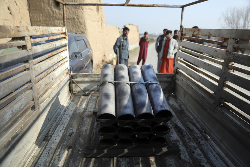 Afghan security personnel stand near a vehicle in which rockets were placed in Bagram, north of Kabul, Afghanistan, Saturday, Dec. 19, 2020. Five rockets were fired at a major U.S. base in Afghanistan on Saturday, but there were no casualties, NATO and provincial officials said. (AP Photo/Rahmat Gul)