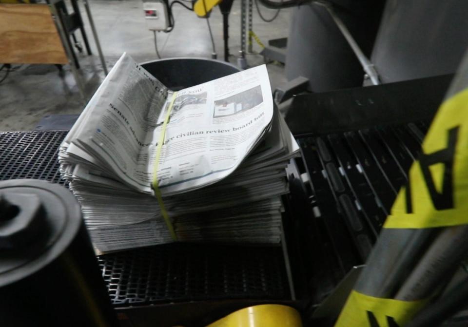 A bundle of newspapers go down a conveyor belt of the print edition for that evening's Courier Journal on March 1, 2021.