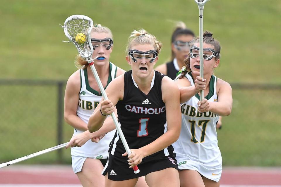 Cardinal Gibbons’ Lexi Mullahy (1) and Kate Mullee (17) defend Charlotte Catholic’s Barbara Tucker (1) during the first half. The Charlotte Catholic Cougars and the Cardinal Gibbons Crusaders met in the NCHSAA 4A Girls Lacrosse Final in Durham , NC on May 19, 2023.