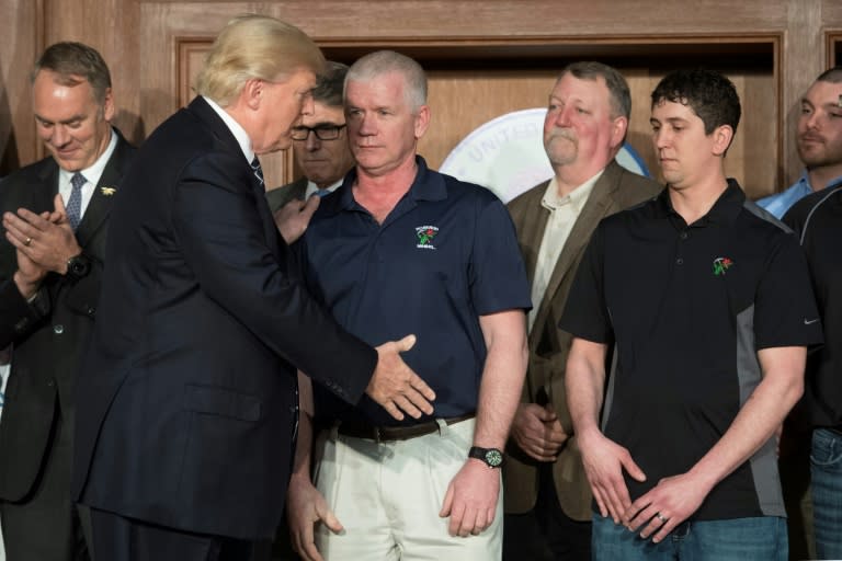 US President Donald Trump (2nd L) shakes hands with miners from Rosebud Mining prior to signing the Energy Independence Executive Order, at the Environmental Protection Agency (EPA) Headquarters in Washington, DC, on March 28, 2017