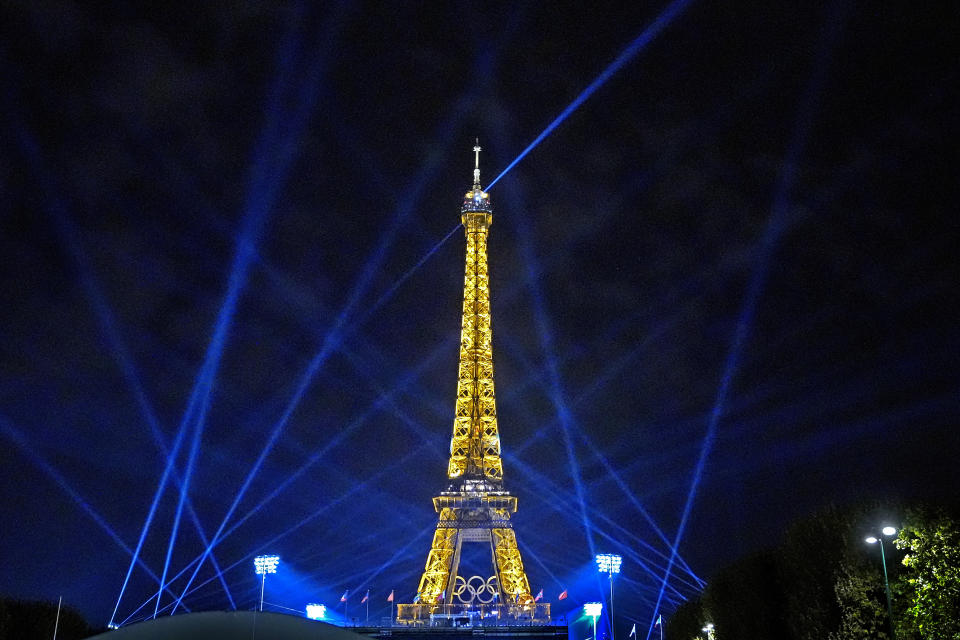 Search lights shine above Eiffel Tower Stadium, the beach volleyball venue at the 2024 Summer Olympics, Tuesday, July 30, 2024, in Paris, France. (AP Photo/Robert F. Bukaty)