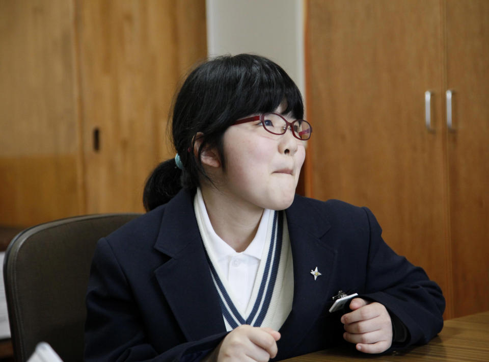 In this Saturday, April 5, 2014 photo, Kokoro Kamiyama, 13, who started her new life after moving from Fukushima, smiles during an interview in Matsumoto, central Japan. Kamiyama is the first child to sign on to the Matsumoto project which Chernobyl-doctor-turned-mayor Akira Sugenoya of Matsumoto offered his Japanese town to get children out of Fukushima. Kamiyama was prone to skipping school when she was in Fukushima, which her mother believes was a sign of stress from worrying about radiation. She is happy she can run around outdoors in the city without wearing a mask. “The air feels so clean here,” Kamiyama said. “I love playing badminton. And tag.” (AP Photo/Koji Sasahara)