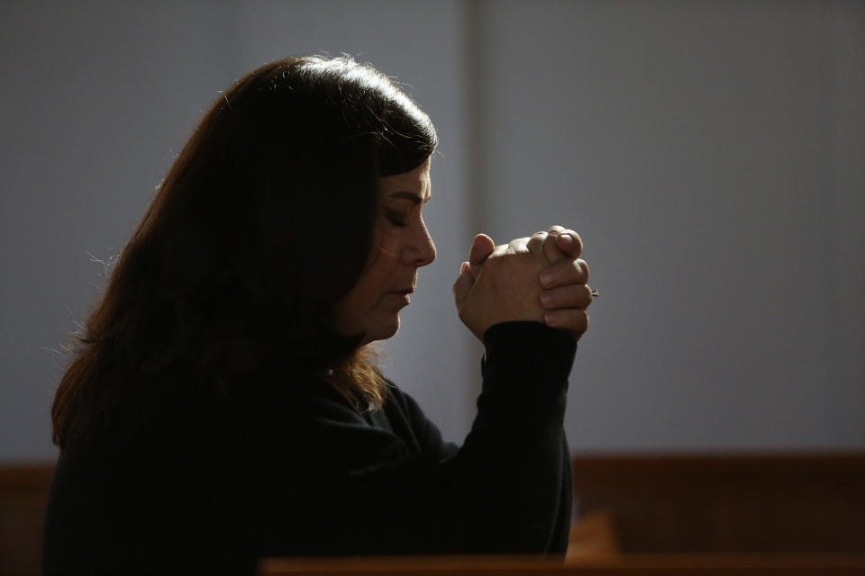 Alison Cerovsky kneels to pray during Mass at Immaculate Conception Catholic Church in Wedowee, Ala., on Sunday, Dec. 12, 2021. (AP Photo/Jessie Wardarski)