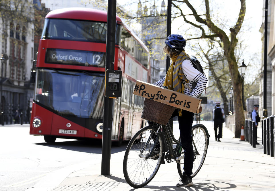 A woman shows a sign on her bicycle as British Prime Minister Boris Johnson is in intensive care fighting the coronavirus in London, Tuesday, April 7, 2020. Johnson was admitted to St Thomas' hospital in central London on Sunday after his coronavirus symptoms persisted for 10 days. Having been in hospital for tests and observation, his doctors advised that he be admitted to intensive care on Monday evening. The new coronavirus causes mild or moderate symptoms for most people, but for some, especially older adults and people with existing health problems, it can cause more severe illness or death.(AP Photo/Alberto Pezzali)