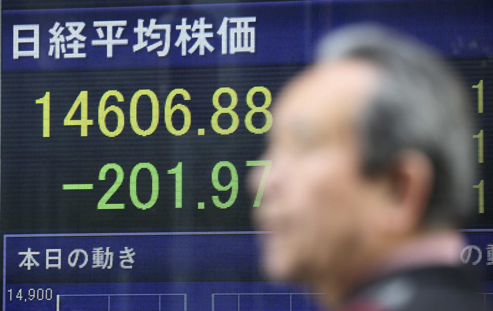 A man walks by an electronic stock price indicator showing the regional heavyweight, Tokyo's Nikkei 225, that shed 201.97 points, or 1.36 percent and closed at 14,606.88, in Tokyo Tuesday, April 8, 2014. Asian stock markets were mixed Tuesday after Japan's central bank refrained from expanding its stimulus and declines in tech stocks weighed on prices. (AP Photo/Eugene Hoshiko)