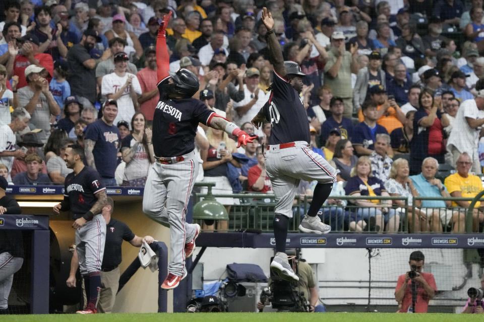 Minnesota Twins' Christian Vazquez celebrates his a two-run home run with Minnesota Twins third base coach Tommy Watkins during the second inning of a baseball game against the Milwaukee Brewers Tuesday, Aug. 22, 2023, in Milwaukee. (AP Photo/Morry Gash)