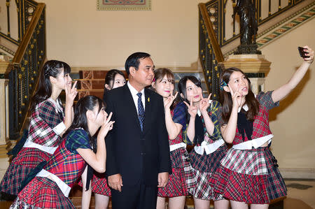 Thailand's Prime Minister Prayuth Chan-ocha poses with Japan idol group AKB48 at Government House in Bangkok, Thailand, September 13, 2018. Thailand Government House/Handout via REUTERS