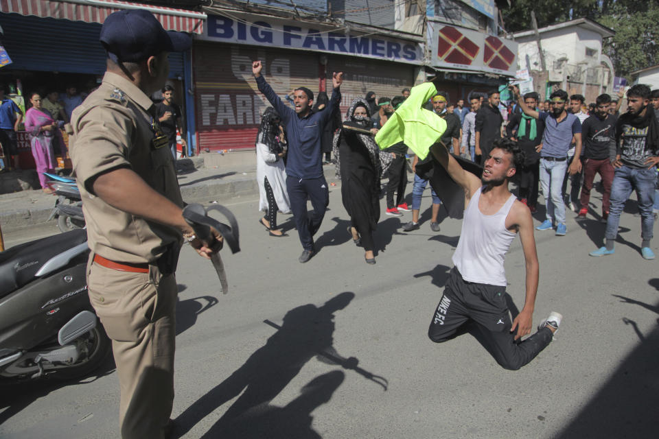 Kashmiri Shiite Muslims shout slogans as they clash with Indian policemen during a Muharram procession in Srinagar, Indian controlled Kashmir, Wednesday, Sept. 19, 2018. Police and paramilitary soldiers on Wednesday used batons and fired tear gas to disperse hundreds of Muslims participating in religious processions in the Indian portion of Kashmir. Authorities had imposed restrictions in parts of Srinagar, the region's main city, to prevent gatherings marking Muharram from developing into anti-India protests. (AP Photo/Mukhtar Khan)