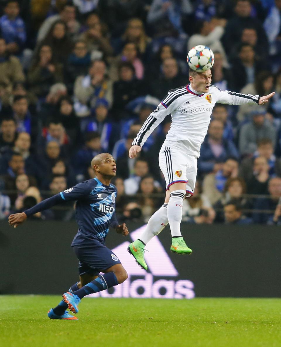 Porto's Yacine Brahimi (L) jumps for the ball with FC Basel's Taulant Xhaka during their Champions League round of 16 second leg soccer match at Dragao stadium in Porto, March 10, 2015. REUTERS/Miguel Vidal (PORTUGAL - Tags: SPORT SOCCER)