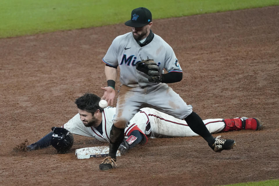 Atlanta Braves' Travis d'Arnaud slides into second base with a double ahead of the throw to Miami Marlins second baseman Jon Berti during the eighth inning of a baseball game Friday, Sept. 25, 2020, in Atlanta. (AP Photo/John Bazemore)