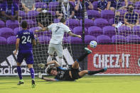 New England Revolution forward Gustavo Bou (7) scores a goal past Orlando City goalkeeper Brian Rowe, bottom, during the first half of an MLS playoff soccer match, Sunday, Nov. 29, 2020, in Orlando, Fla. (AP Photo/Matt Stamey)