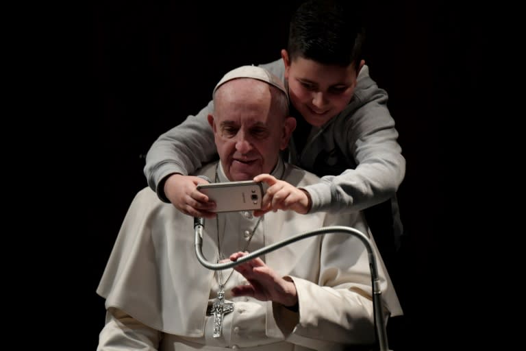 A boy takes a selfie photo with Pope Francis at the church of St. Maria Josefa in Castelverde outside Rome