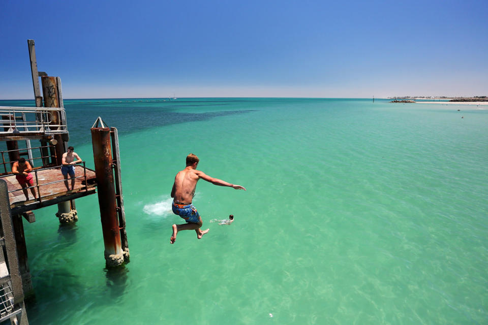 A teen jumps off the Glenelg jetty in Adelaide. Source: Getty Images