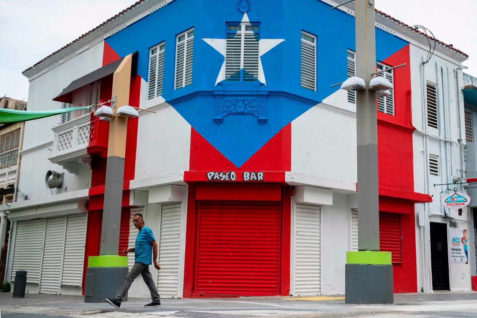 A man walks through a closed commercial area in San Juan, Puerto Rico on March 25, 2020.