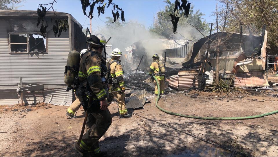 Las Cruces firefighters inspect what's left of a mobile home after a morning fire Monday, June 13, 2022. The mobile home was in a trailer park near 3 Crosses Avenue and Alameda Boulevard.