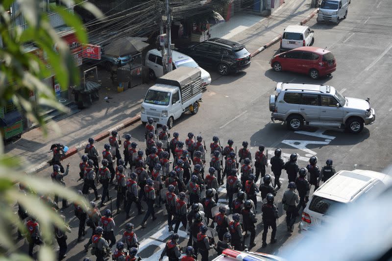 FILE PHOTO: Riot police walk in the middle of a street during a protest against the military coup in Yangon