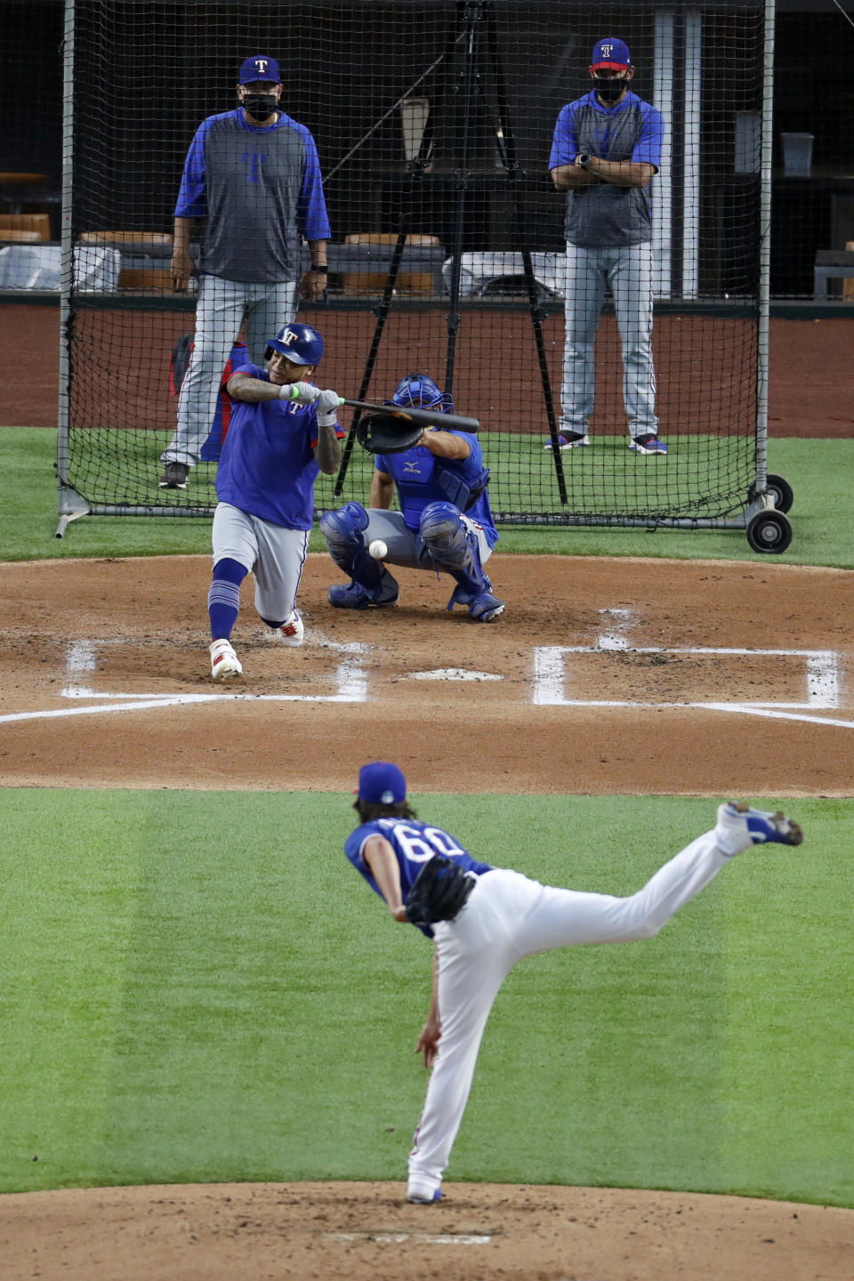 Texas Rangers' Luke Farrell throws to Willie Calhoun as catcher Jeff Mathis, pitching coach Julio Rangel, left rear and manager Chris Woodward, right rear, look on during a baseball practice at Globe Life Field in Arlington, Texas, Friday, July 3, 2020. (AP Photo/Tony Gutierrez)