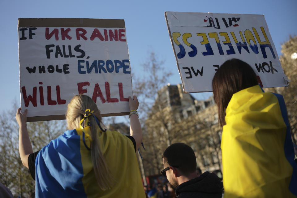 A protestor hold a poster during a demonstration against the war in Ukraine, Sunday, March 27, 2022 in Paris. Russia's invasion of Ukraine, now in its 32nd day, has stalled in many areas. (AP Photo/Lewis Joly)