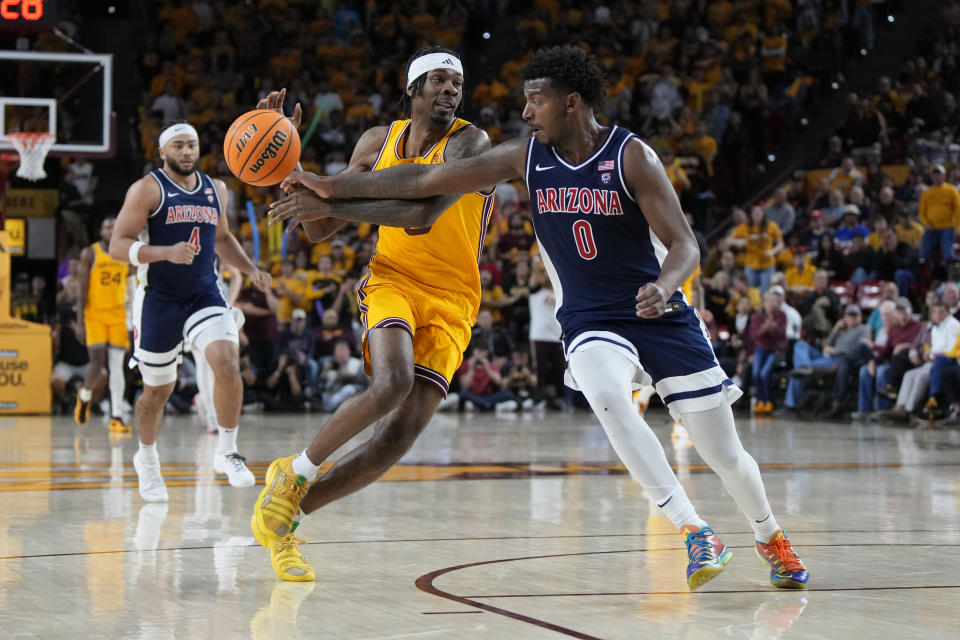 Arizona guard Jaden Bradley (0) knocks the ball away from Arizona State guard Jamiya Neal during the second half of an NCAA college basketball game Wednesday, Feb. 28, 2024, in Tempe, Ariz. Arizona won 85-67. (AP Photo/Rick Scuteri)