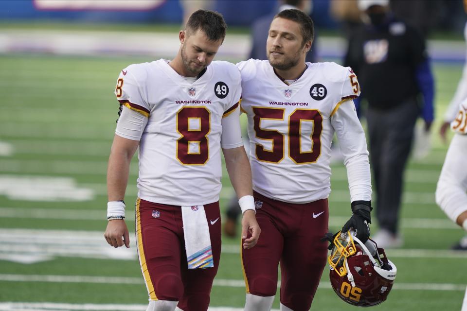 Washington Football Team quarterback Kyle Allen (8) is comforted by Jared Norris (50) after an NFL football game against the New York Giants, Sunday, Oct. 18, 2020, in East Rutherford, N.J. (AP Photo/John Minchillo)