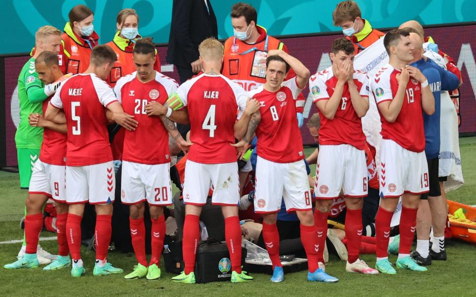 Denmark players surround Christian Eriksen – Christian Eriksen collapses: How a night of horror and hope unfolded in Copenhagen - EPA