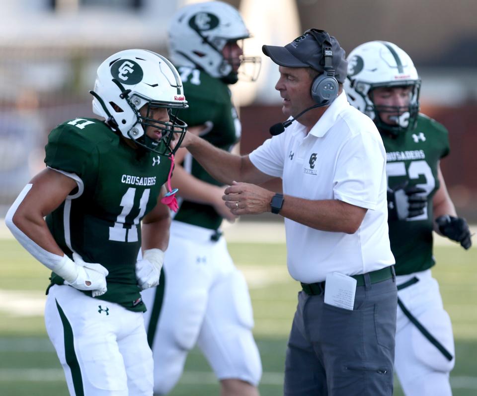 Central Catholic head coach Jeff Lindesmith instructs T'Kye Wells (11) during a Thursday, Aug. 19, 2021 high school football game at Central against Perry.