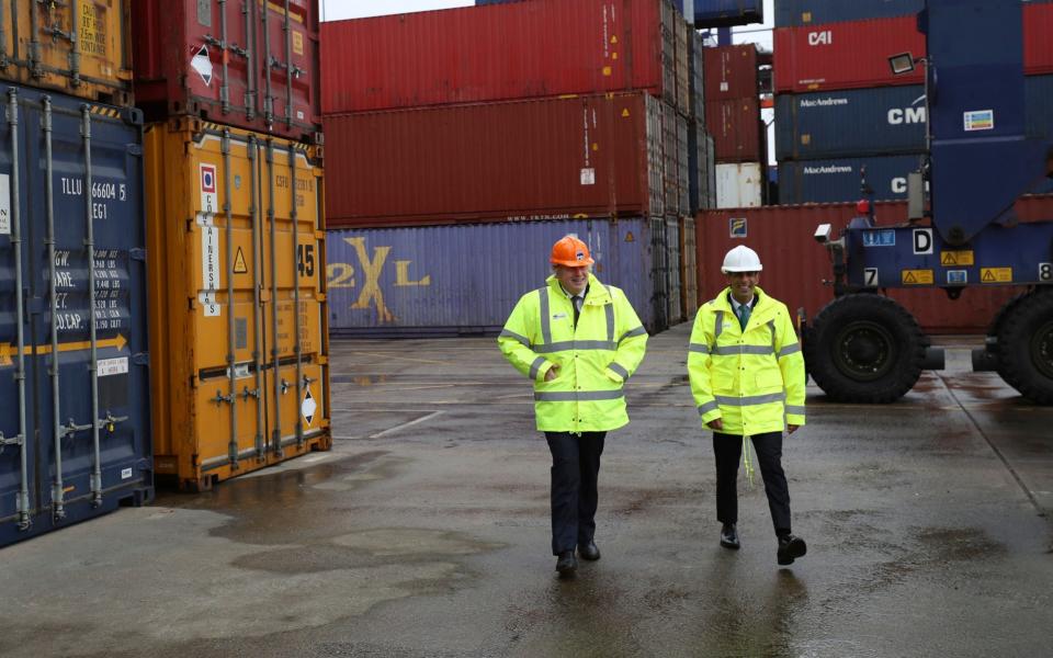 Boris Johnson and Rishi Sunak walk past shipping containers during a visit to Teesport in Middlesbrough - PA