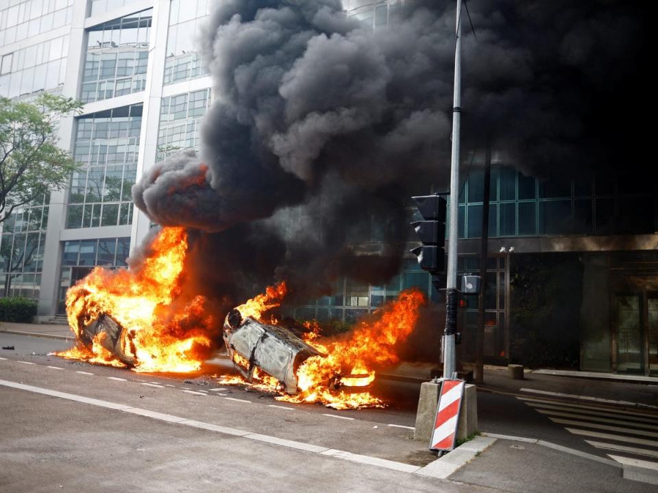 Burning vehicles are seen in a street in Nanterre amid clashes between protesters and police (Sarah Meyssonnier/Reuters)