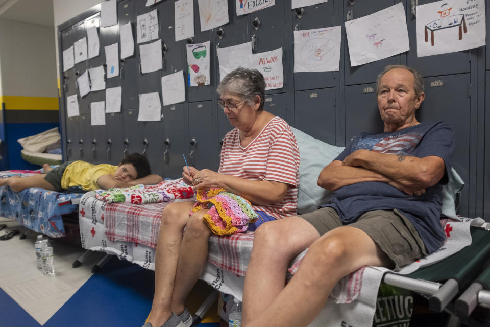 Gordon and Dina Reynolds, with their 11-year-old granddaughter, Abby, sit on cots in the hall way of the North Myrtle Beach High School that is currently being used as a Red Cross evacuation shelter Wednesday, Sept. 4, 2019 in North Myrtle Beach, S.C. Weakened but still deadly, Hurricane Dorian crept up the Southeastern coast of the United States and millions were ordered to evacuate as forecasters said near-record levels of seawater and rain could inundate Georgia and the Carolinas. (Jason Lee/The Sun News via AP)