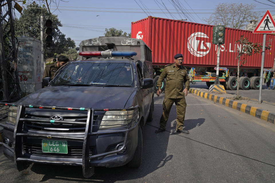 Police officers stand guard at a barricaded road leading to the residence of former Prime Minister Imran Khan, in Lahore, Pakistan, Thursday, March 16, 2023. A Pakistani court on Thursday extended a pause for a day in an operation aimed at arresting the former premier Khan, a sign of easing tension in the country's cultural capital of Lahore where 24-hours-long clashes erupted this week when police tried to arrest Khan for failing to appear before a court in the capital. (AP Photo/K.M. Chaudary)