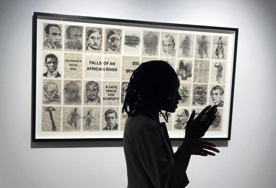 In this photo taken on Saturday, Nov, 10, 2018, a visitor looks at charcoal drawings by artist William Kentridge paying homage to Africans' service in World War 1, at the Goodman Gallery in Johannesburg. Amid the fanfare marking the 100th anniversary of the end of World War I, little has been said about some crucial participants in the conflict: Africans. More than 1 million African soldiers, laborers and porters were vital actors in the war in Europe and especially in battles on the African continent, yet little commemorates their role. (AP Photo/Andrew Meldrum)