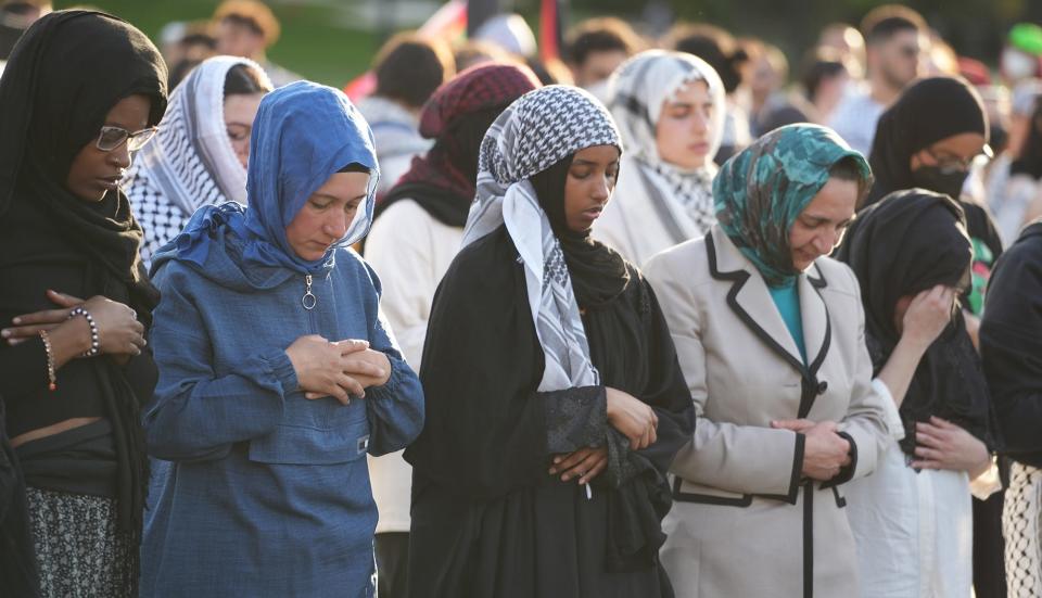 Women pray Wednesday evening during protests at Ohio State University's South Oval, where demonstrators are calling for a ceasefire and end to the Israel-Hamas war to protect Palestinian civilians and are repeating demands for the university to divest investment in Israel. OSU has previously said it cannot divest from investments in Israel under Ohio law.