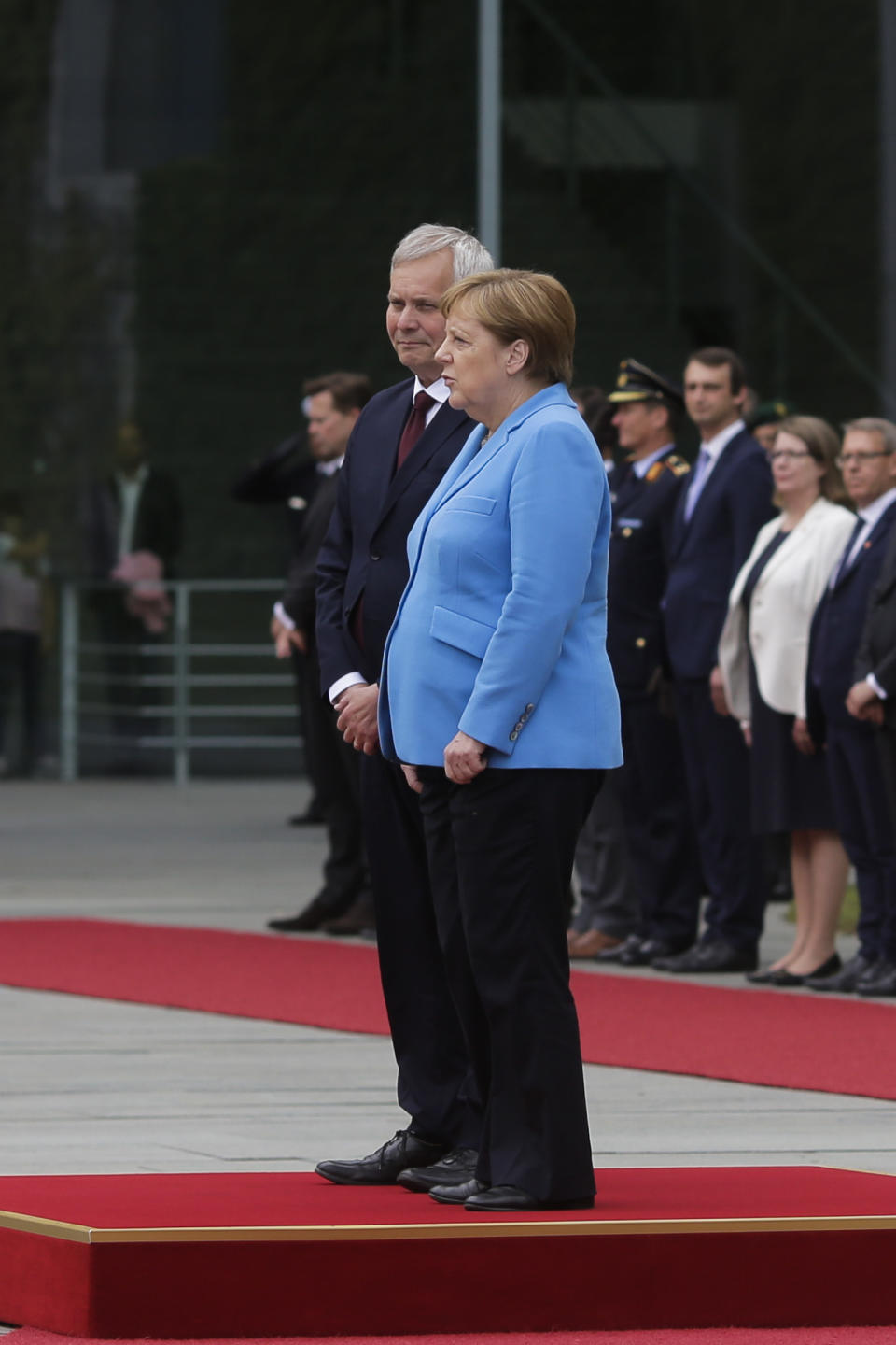 German Chancellor Angela Merkel, right, and Prime Minister of Finland Antti Rinne listen to the national anthems at the chancellery in Berlin, Wednesday, July 10, 2019. Merkel's body shook visibly as she stood alongside the Finnish prime minister and listen to the national anthems during the welcoming ceremony at the chancellery. (AP Photo/Markus Schreiber)