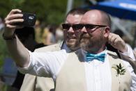 A couple takes a selfie before "The Celebration of Love", a grand wedding where over 100 lesbian, gay, bisexual and transgender (LGBT) couples will get married, at Casa Loma in Toronto, June 26, 2014. Toronto is hosting WorldPride, a week-long event that celebrates the LGBT community. REUTERS/Mark Blinch (CANADA - Tags: SOCIETY)