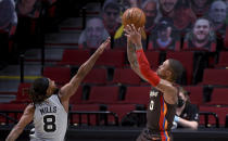 Portland Trail Blazers guard Damian Lillard shoots over San Antonio Spurs guard Patty Mills during the first half of an NBA basketball game in Portland, Ore., Saturday, May 8, 2021. (AP Photo/Steve Dykes)