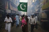 A man and his daughter wave an Islamic religious flag they participate in a procession to mark Eid-e-Milad-ul-Nabi, or birthday celebrations of Prophet Mohammad in Mumbai January 14, 2014. REUTERS/Danish Siddiqui (INDIA - Tags: RELIGION SOCIETY)