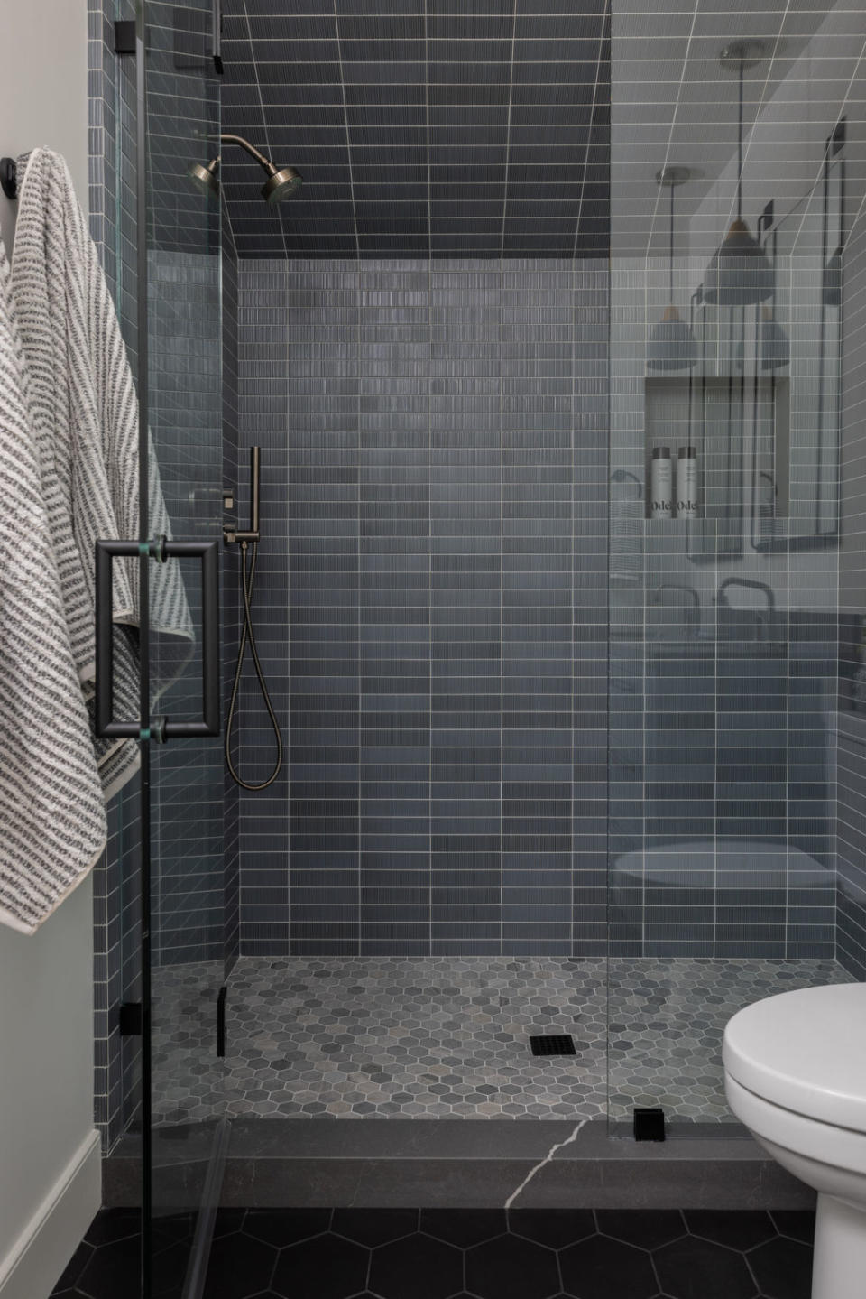 A  shower with blue tiles walls and mosaic tiles floor