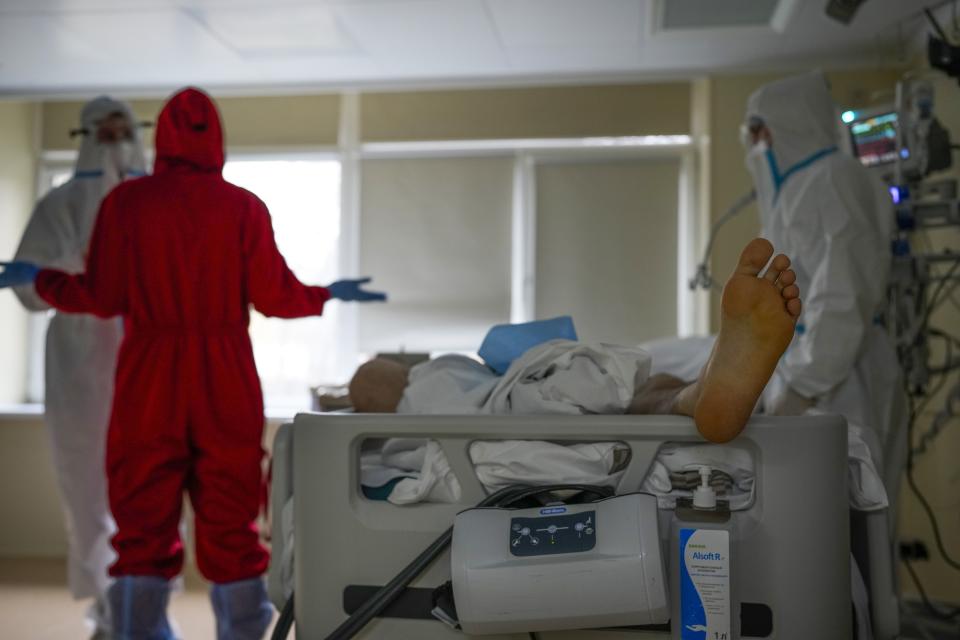 Medics wearing special suits to protect against coronavirus make a briefing as they come to treat a patient with coronavirus at an ICU at the Moscow City Clinical Hospital 52, in Moscow, Russia, Tuesday, Oct. 19, 2021. Russia hit another daily record of coronavirus deaths Tuesday as rapidly surging infection rates raised pressure on the country's health care system and prompted the government to suggest declaring a nonworking week.(AP Photo/Alexander Zemlianichenko)