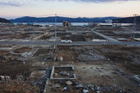 In this Feb. 23, 2012, file photo, a car passes through the leveled city of Minamisanriku, Miyagi Prefecture, northeastern Japan, almost one year after the March 11 tsunami. (AP Photo/David Guttenfelder, File)