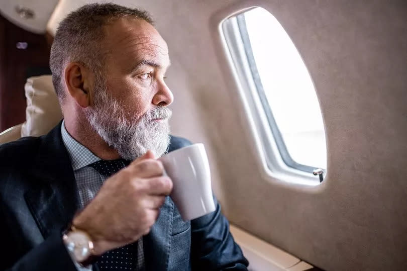 Traveller enjoys a cup of tea during the flight