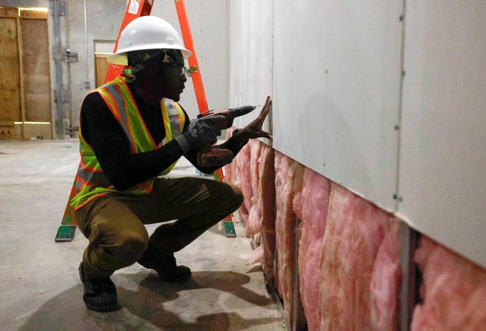 Carey Myers hangs drywall at a construction site subcontracted to Post L Group, a Black owned business. Myers is part of the nonprofit Building Pathways, founded by Jeff Postel of Post L Group. The nonprofit works to introduce young members of the Black community to the construction industry and support their career growth within it.