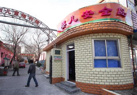 People walk past next to a baby hatch named "baby safety island" at the Tianjin Institute of Children's Welfare, in Tianjin municipality, December 27, 2013. REUTERS/Stringer