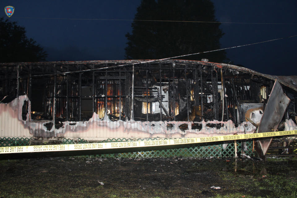 This photo provided by Louisiana State Fire Marshal’s Office shows mobile home that was set on fire in Mamou, La. The Louisiana State Fire Marshal’s Office says a man wearing nothing below the waist has been arrested and accused of setting fire to a mobile home occupied by a woman, a baby and two other children. The fire marshal's office says 33-year-old James Rozas of Mamou was arrested Friday, April 9, 2021 on charges of arson, attempted murder and violating a protective order after the pre-dawn fire. (Louisiana State Fire Marshal’s Office via AP)