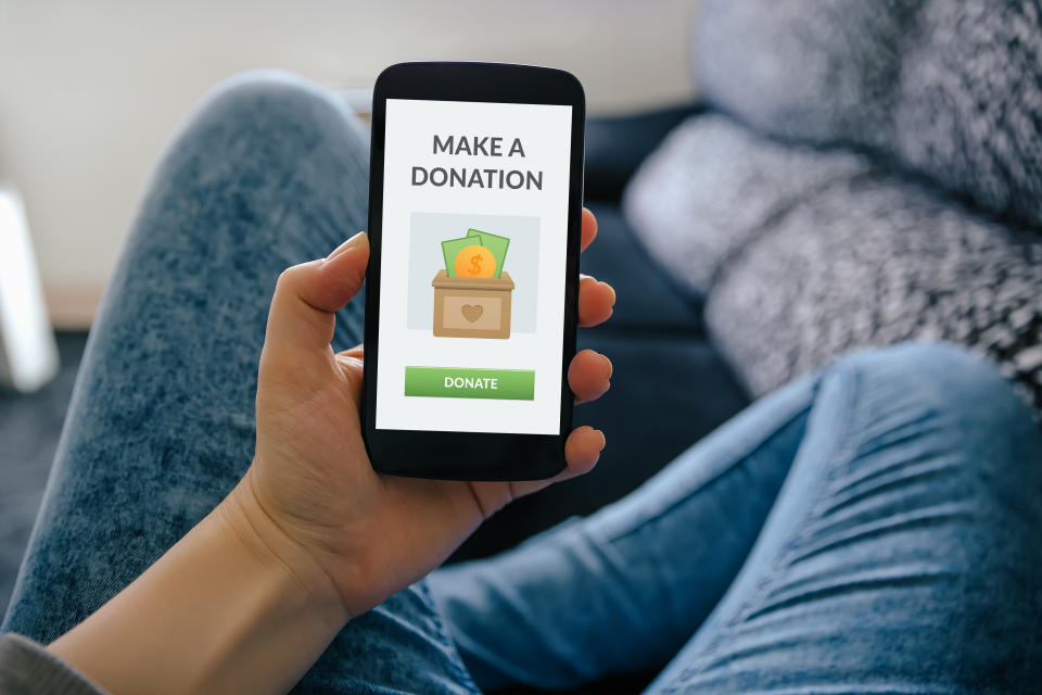 Girl holding smart phone with donation concept on screen